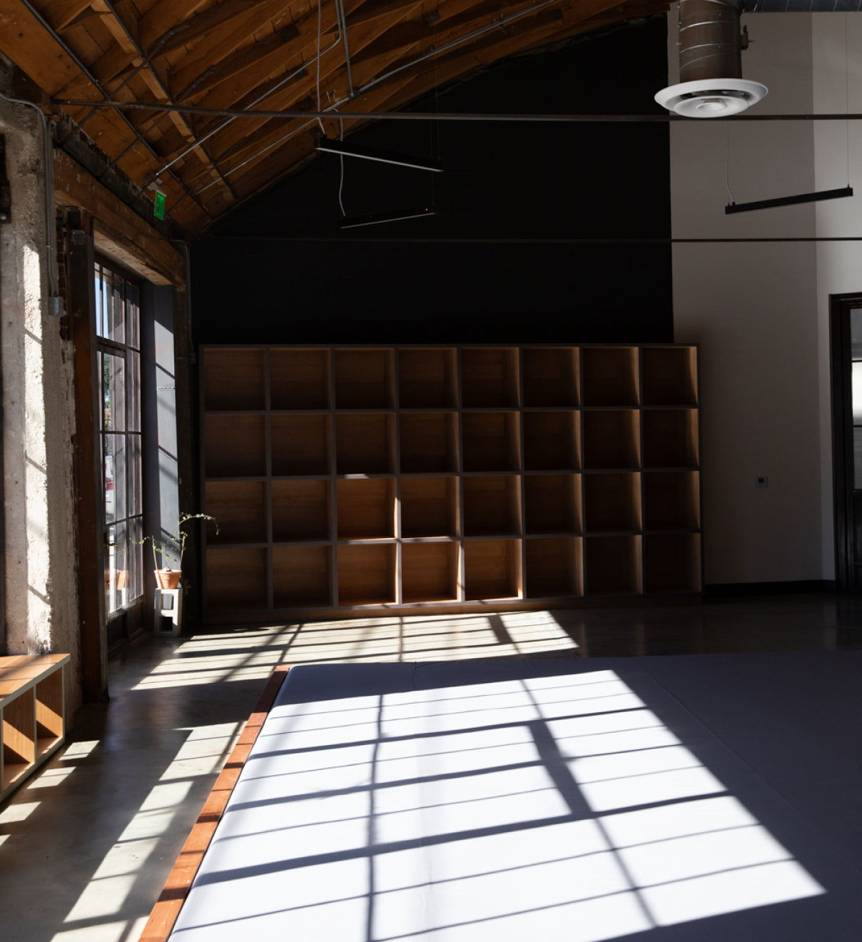 Storage cubbies and mat space bathed in sunlight at Frogtown Jiu-Jitsu